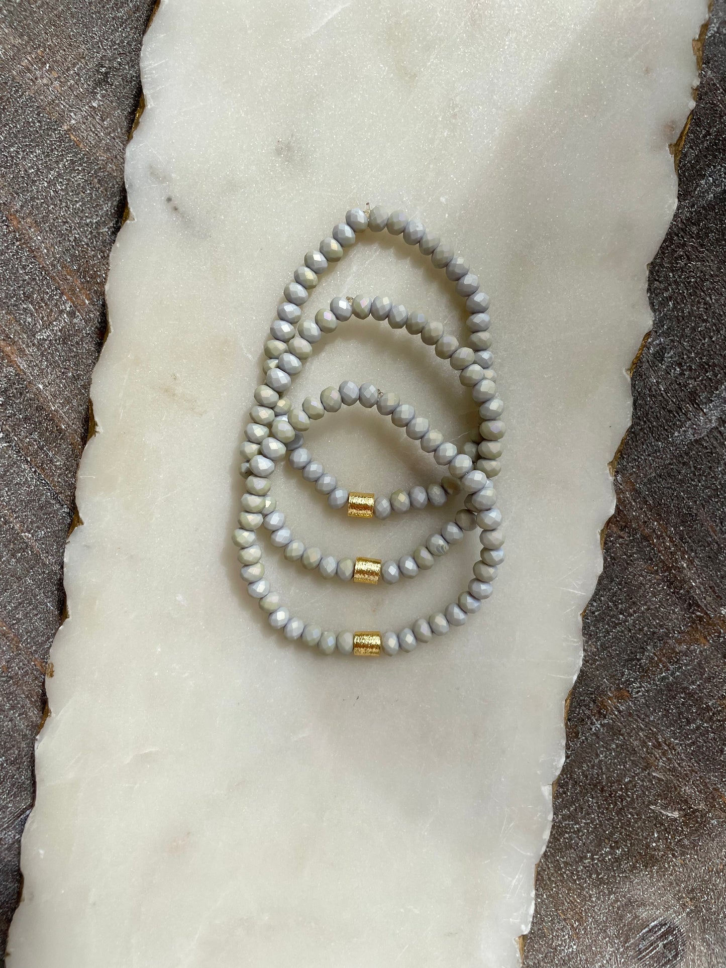 Light gray beaded bracelet with gold accents